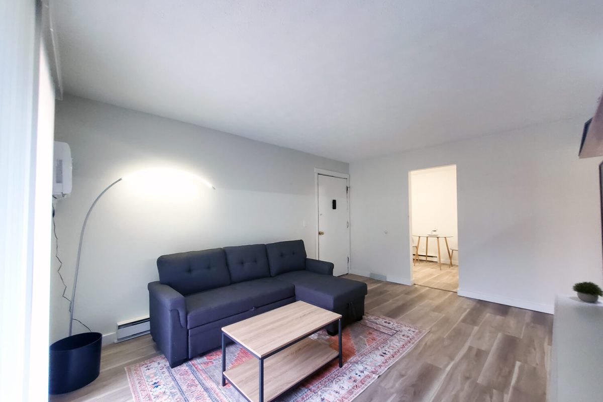 Open living area with navy sectional and coffee table in a renovated 1 bedroom, Hall of Fame Apartments, Canton OH